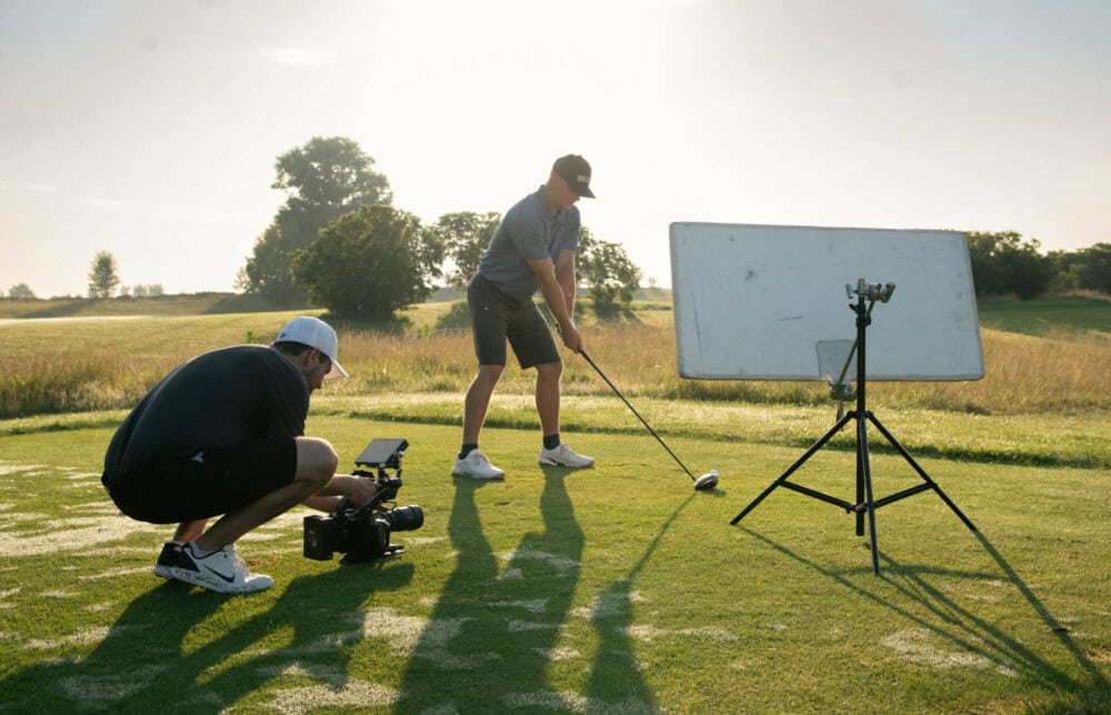 Golf shot being filmed outdoors on a green field, professional video production, sports videography, Mills James.